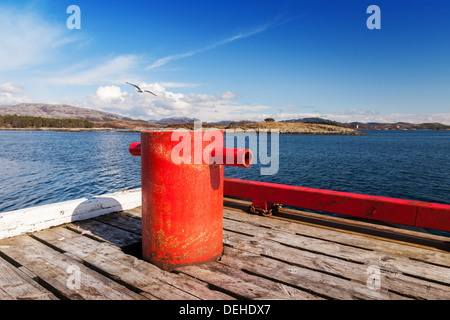 Rosso bollard ormeggio sul molo di legno in Norvegia Foto Stock