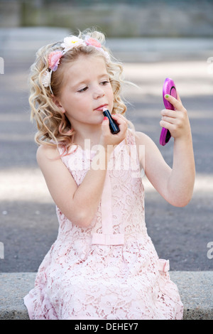 Piuttosto di sette anni che indossa la ragazza rosa e il rossetto Foto Stock