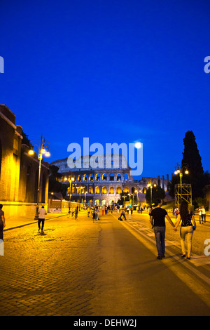 La gente che camminava per strada con un anfiteatro in background, Colosseo, Roma, lazio, Italy Foto Stock