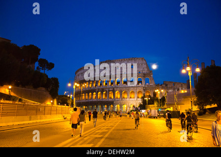 La gente che camminava per strada con un anfiteatro in background, Colosseo, Roma, lazio, Italy Foto Stock