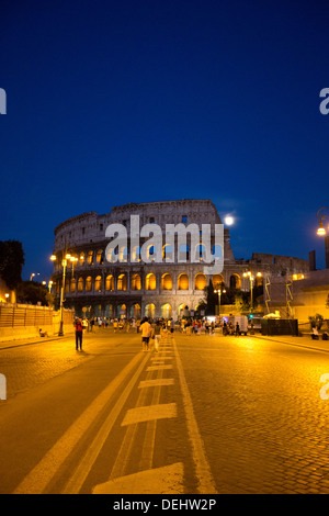 La gente che camminava per strada con un anfiteatro in background, Colosseo, Roma, lazio, Italy Foto Stock