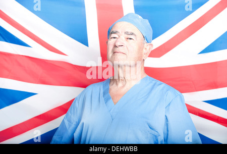 Ritratto di un adulto Senior chirurgo davanti una bandiera britannica Foto Stock