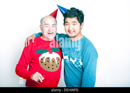 Ritratto di Senior adulto uomo un giovane uomo asiatico indossando i ponticelli di Natale party cappelli Foto Stock