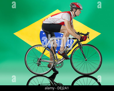 Ciclista maschio ciclismo anteriore bandiera brasiliana Foto Stock