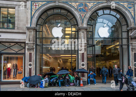 Londra, Regno Unito. Xix Sep, 2013. La coda per il lancio di Apple i-phone 5 huddles sotto gli ombrelli sotto la pioggia. Credito: Guy Bell/Alamy Live News Foto Stock
