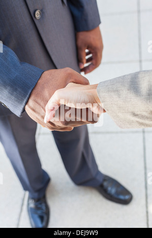 African American businessman o man mano tremante con un bianco o imprenditrice donna collega femmina facendo un affare di lavoro Foto Stock