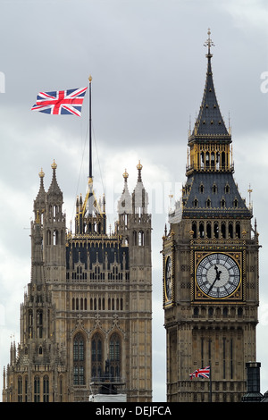 Unione Jack volare in condizioni di vento forte oltre il Big Ben e il Parlamento costruire torri a Londra in Inghilterra Foto Stock