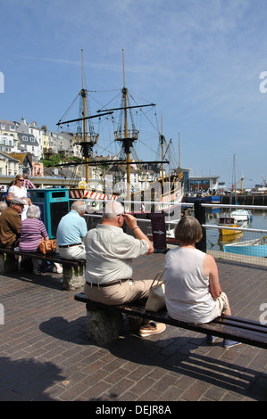 Giovane seduto su un banco di lavoro, Brixham, Devon, Inghilterra, Regno Unito Foto Stock