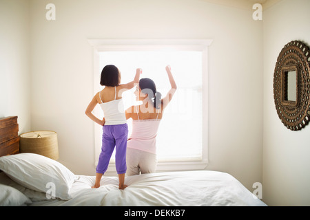 Madre e figlia giocando sul letto Foto Stock