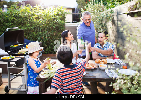 Famiglia tostare ogni altro a tavola all'aperto Foto Stock