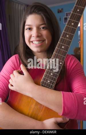 Ragazza ispanica abbracciando la chitarra Foto Stock