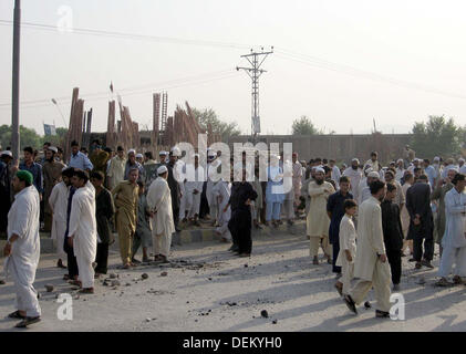 I residenti di Achini Bala bloccato la strada come stanno protestando contro bombe a mano l attacco a una moschea in Achini Bala area di Peshawar, Venerdì, 20 settembre 2013. L esplosione è avvenuta nei pressi di una moschea durante un raduno di persone era ancora presente all'interno. Tre persone sono state uccise e molte ferite in un'esplosione. Foto Stock