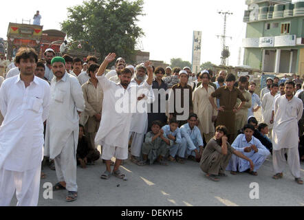 I residenti di Achini Bala bloccato la strada come stanno protestando contro bombe a mano l attacco a una moschea in Achini Bala area di Peshawar, Venerdì, 20 settembre 2013. L esplosione è avvenuta nei pressi di una moschea durante un raduno di persone era ancora presente all'interno. Tre persone sono state uccise e molte ferite in un'esplosione. Foto Stock