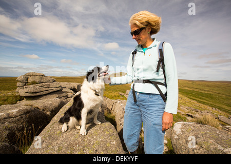 Tori di granito su Ger tor, Dartmoor Devon, Regno Unito, con una donna walker e cane. Foto Stock