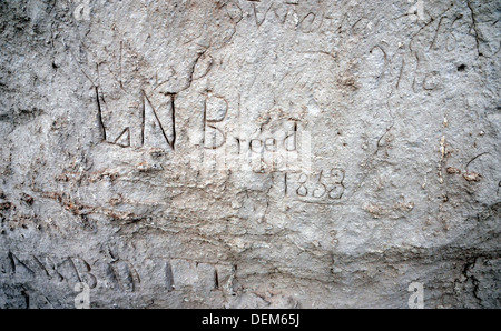 Il nome di un 700 scolpiti i loro nomi hemigrant e utente della Oregon Trail scolpito nella pietra arenaria morbida a Register Cliff, vicino a Guernsey, Wyoming. Foto Stock