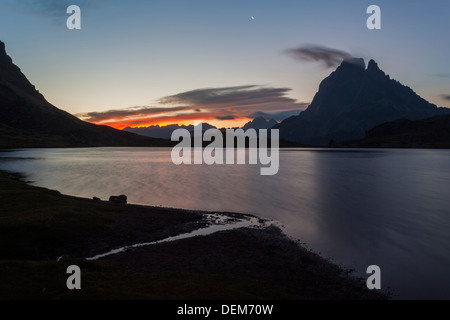 Il Midi d'Ossau al sorgere del sole con la luna nel lago Ayous, Pyrénées-Atlantiques, Francia, Europa Foto Stock