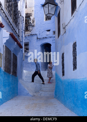 Due giovani ragazzi in un vicolo con blue case dipinte a Chefchaouen, Marocco Foto Stock