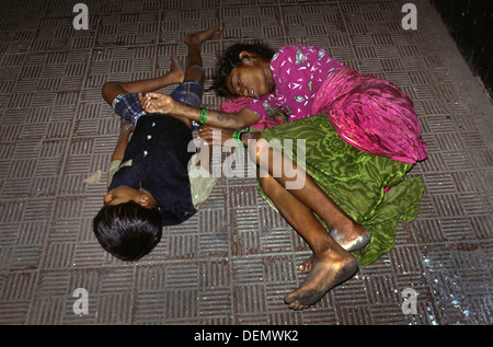 Un senzatetto donna che dorme con suo figlio sul marciapiede in Mumbai India Foto Stock