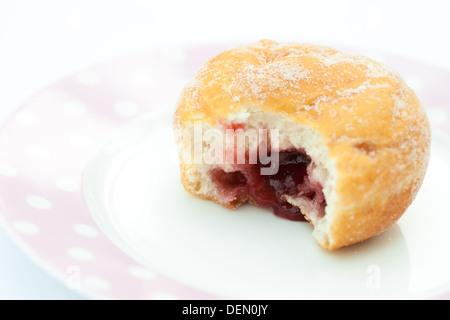 Jam ciambella con un boccone prelevato e marmellata che mostra, su di una piastra Foto Stock