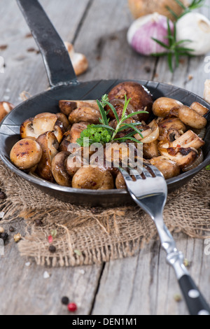 I funghi in una padella vintage con erbe fresche Foto Stock