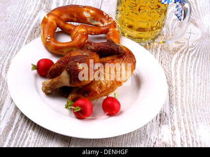 Pollo per Oktoberfest con birra, pretzel e ravanelli, vista dall'alto Foto Stock