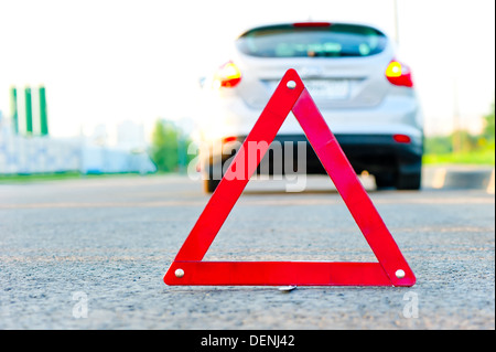Triangolo e un auto con l'allarme di emergenza Foto Stock