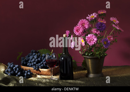 Still-life con bouquet di fiori autunnali e uve scuro Foto Stock