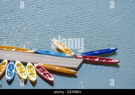 Barche in plastica ancorato in un molo in legno Foto Stock