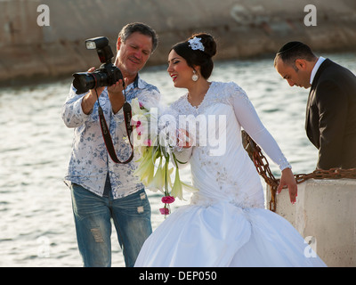 Una giovane coppia il loro giorno di nozze che è fotografata al vecchio porto di Jaffa in Israele Foto Stock