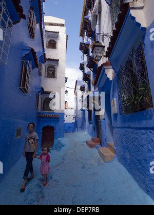 Due ragazze in vicolo blu con pareti dipinte, Chefchaouen, Marocco Foto Stock