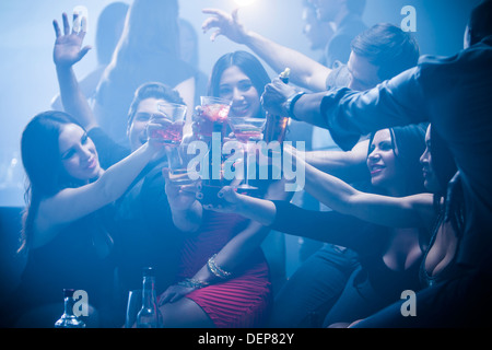 Amici tostare ogni altra in discoteca Foto Stock