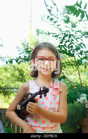 Ragazza ispanica holding violino all'aperto Foto Stock