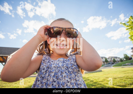 Ragazza caucasica indossando occhiali da sole all'aperto Foto Stock