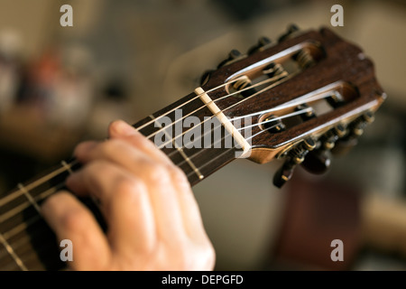 Chiusura del liutaio Tuning e prove di chitarra acustica in officina Foto Stock