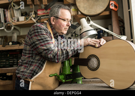 Liutaio finitura chitarra acustica in officina Foto Stock