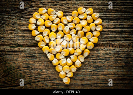 Granella di mais su una vecchia tavola di legno Foto Stock