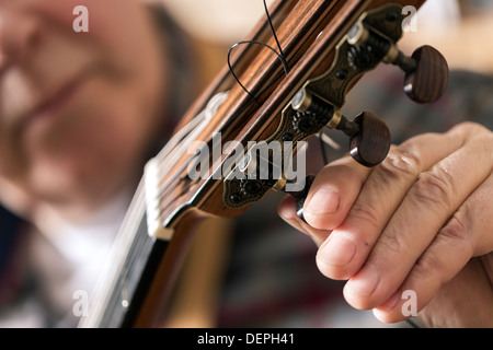 Chiusura del liutaio Tuning e prove di chitarra acustica in officina Foto Stock