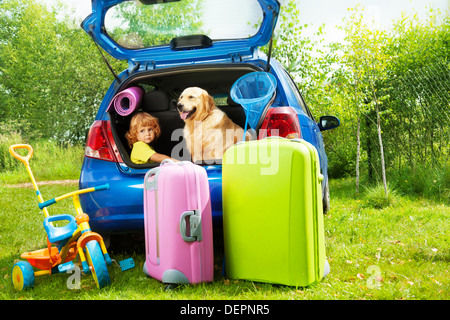 Chiudere riprese di una vettura con retriever cane e tre anni vecchio ragazzo in attesa in linea con i sacchetti per il viaggio, trickle, sfera, convogliatore-net Foto Stock