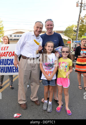 Bellmore, New York, Stati Uniti Il 22 settembre 2013. Stati Uniti Il senatore Charles 'chuck' SCHUMER (Democratico), pone con GLEN FARRELL, e le sue figlie BRIANNA FARRELL, 10 e Keira Farrell, 8, la ventisettesima edizione del Festival Bellmore, dotate di divertimento per tutta la famiglia con mostre e attrazioni in un 25 blocco quadrato area, con oltre 120.000 persone che dovrebbero partecipare nel corso del fine settimana. Il senatore Schumer è in esecuzione per la rielezione a novembre. Credito: Ann e Parry/Alamy Live News Foto Stock