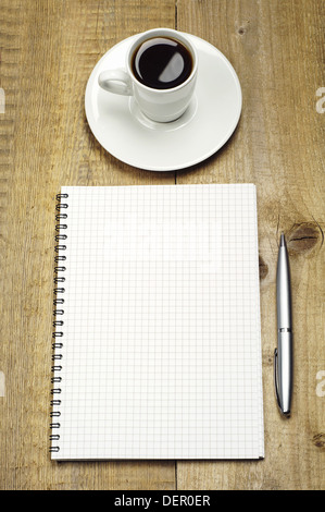 Il Blocco note e penna e la tazza di caffè su di un tavolo di legno Foto Stock