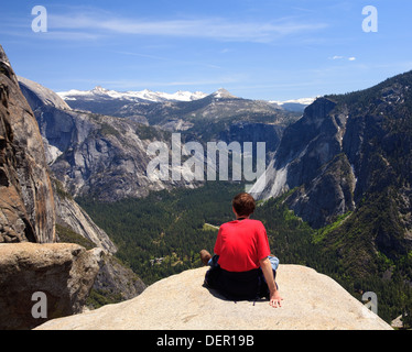 Escursionista guardando la vista da Yosemite Falls con la Sierra Nevada in Yosemite National Park, California, Stati Uniti d'America Foto Stock
