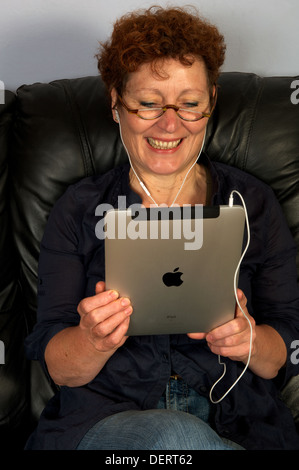 La donna guarda Live TV utilizzando un iPad di Apple computer tablet Foto Stock