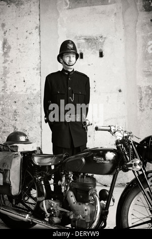 Uomo in 1940's 40s uniformi della polizia e Royal Enfield bici del motore Foto Stock