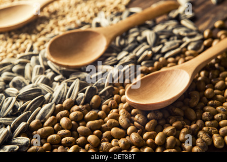 Cucchiai di legno e i chicchi di cereali sul tavolo di legno Foto Stock