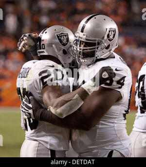 Denver, Colorado, Stati Uniti d'America. 23 sett, 2013. Oakland Raiders RB DARREN MCFADDEN, sinistra, ottiene congrats dopo segnando un rushing TD per il suo team durante il 4° trimestre all autorità sportive Field at Mile High lunedì notte. I Broncos battere i raider 37-21. Credito: Hector Acevedo/ZUMAPRESS.com/Alamy Live News Foto Stock