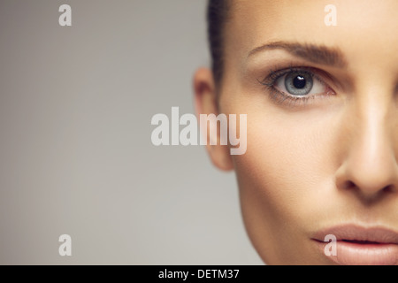 Close-up ritratto di bella donna giovane con perfetta una pelle sana e bella occhi. Metà faccia di bella giovane femmina Foto Stock