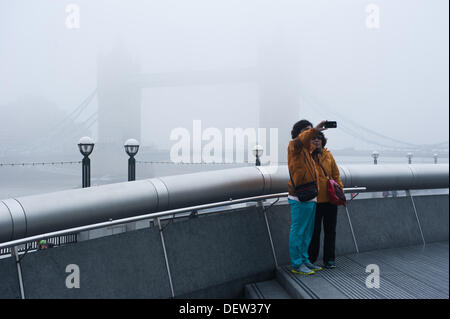 London, Regno Unito - 24 Settembre 2013: turisti scattare foto di Tower Bridge come una fitta nebbia copre la città di Londra nelle prime ore del giorno di credito: Piero Cruciatti/Alamy Live News Foto Stock