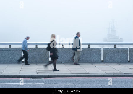 London, Regno Unito - 24 Settembre 2013: pendolari a piedi sul ponte di Londra come una fitta nebbia copre la città di Londra nelle prime ore del giorno Foto Stock