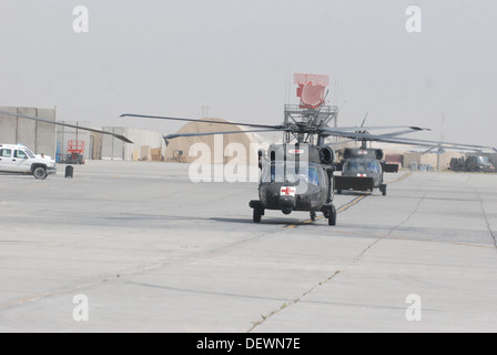 Una coppia di HH-60M Black Hawk evacuazione medica elicotteri equipaggi composti da membri della C Company (DUSTOFF), 3° Battaglione (supporto generale), decimo combattere la Brigata Aerea, Task Force Phoenix, taxi per il paziente drop-off posizione fuori Heathe N. Craig giunto la Foto Stock