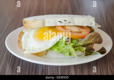 Sandwich freschi con i pomodori, lattuga e uovo fritto sul piatto Foto Stock